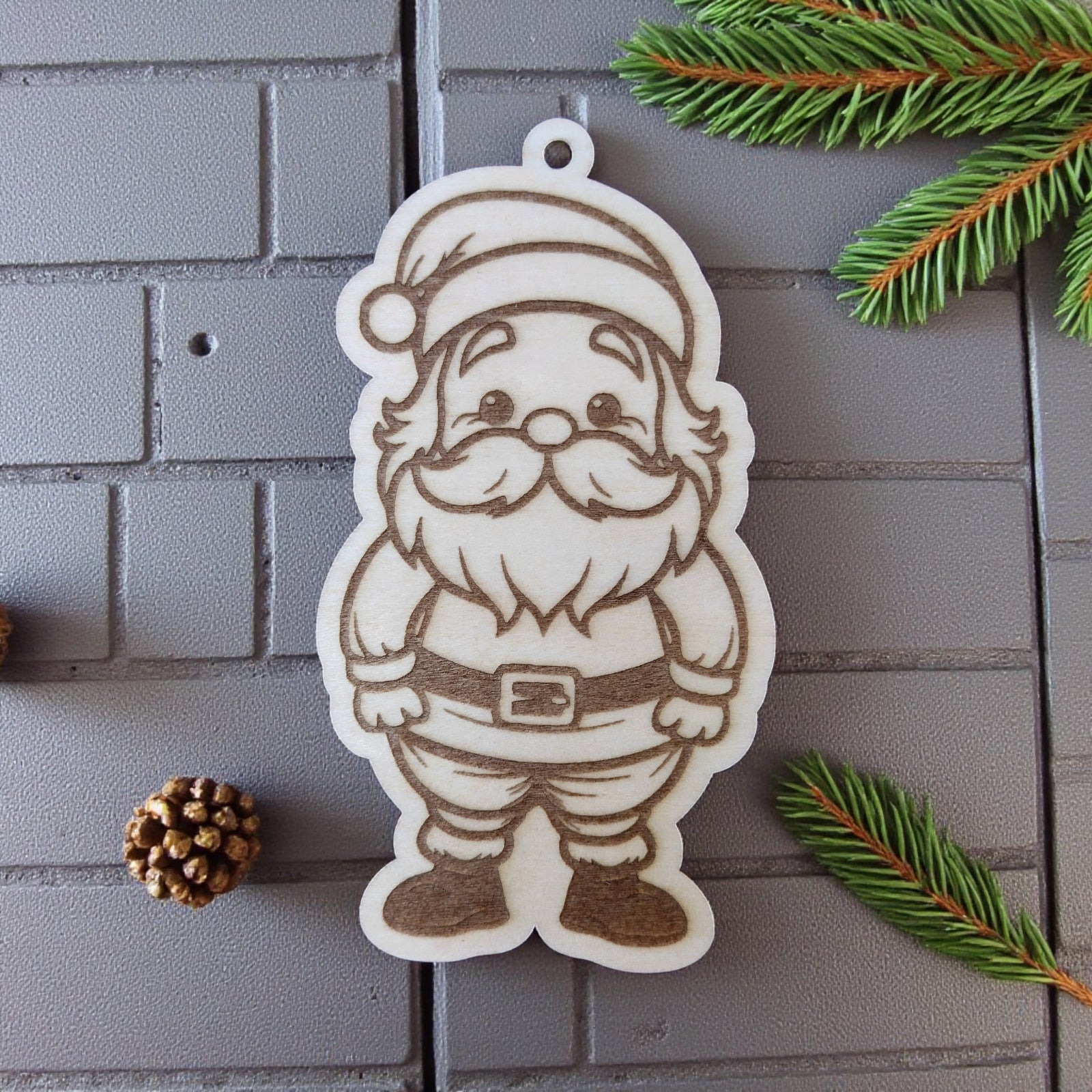 Santa Claus ornament with hat and beard, engraved on natural wood.