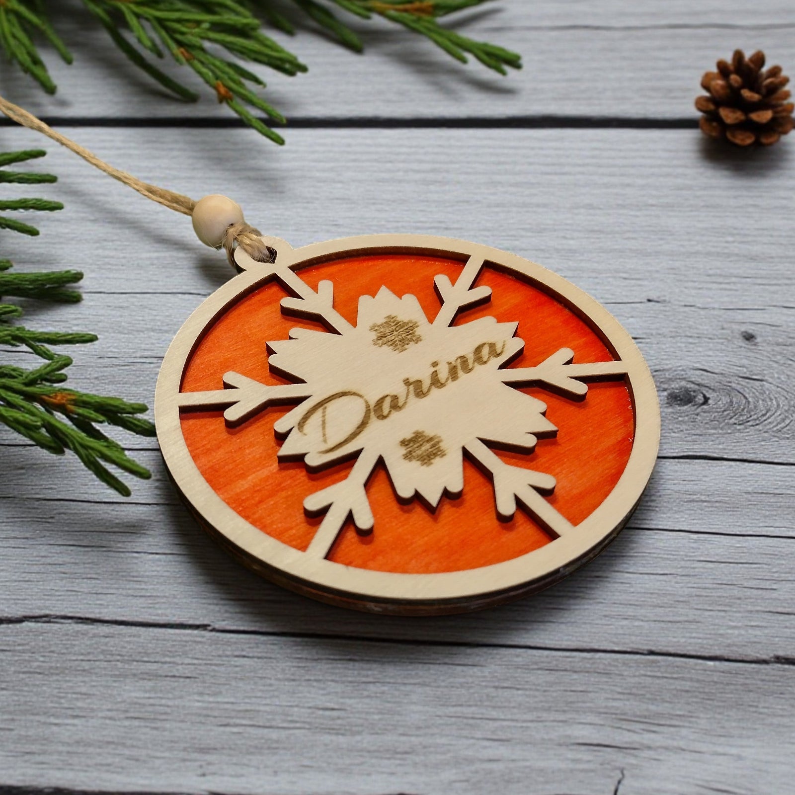 Personalised wooden snowflake ornament with engraved name and orange
