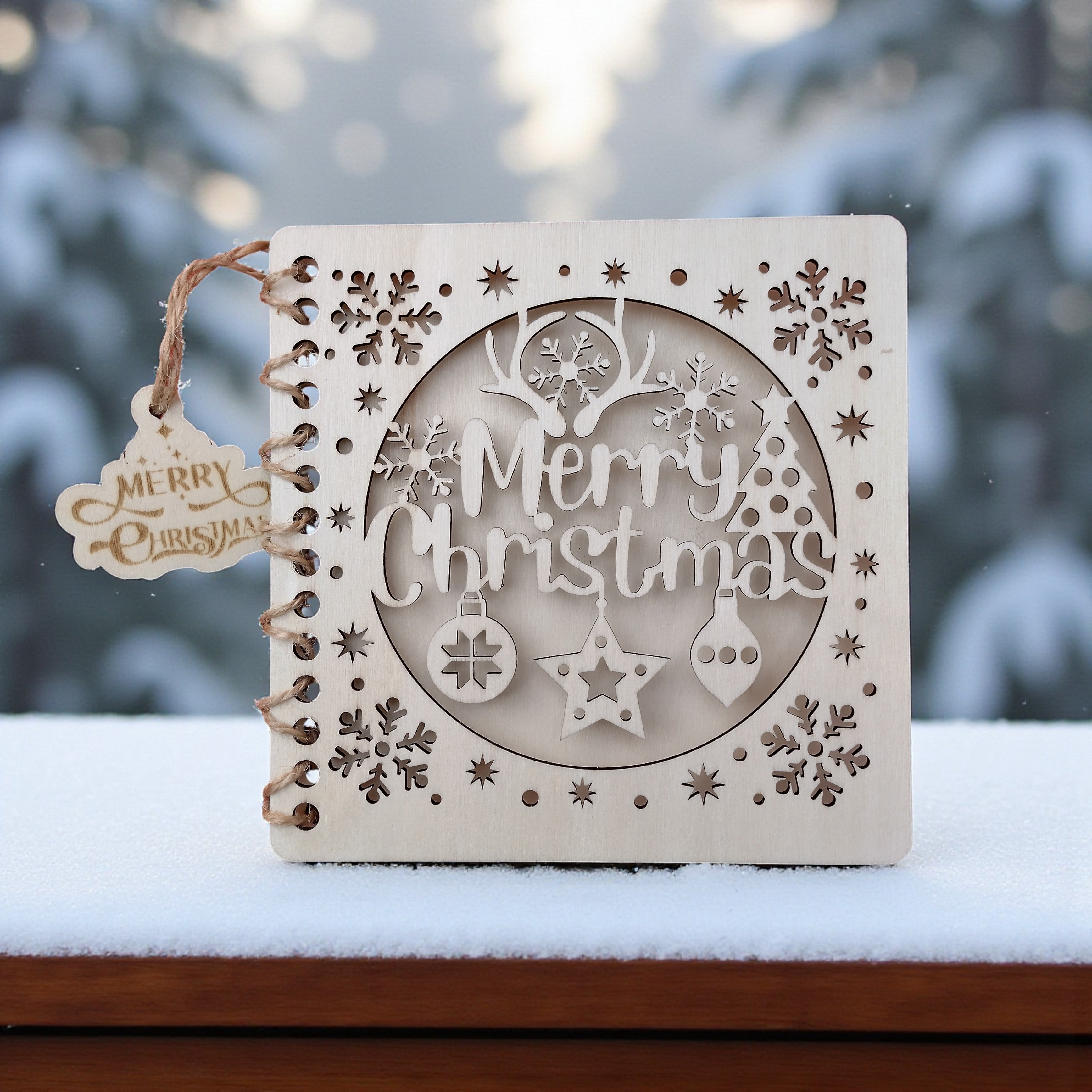 Wooden “Merry Christmas” card displayed outdoors on snow, laser-cut festive card made from sustainable wood.