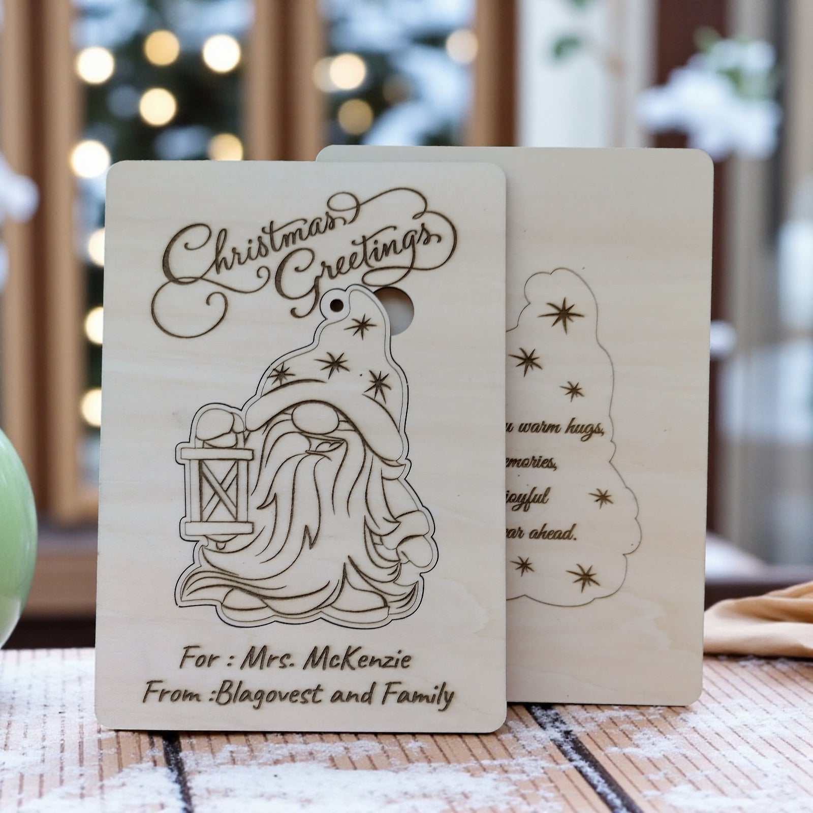 Wooden Christmas card with engraved gnome displayed in cozy festive scene